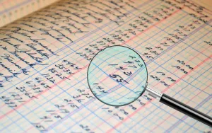 Audit & Investigation Magnifying glass on a paper being audited
