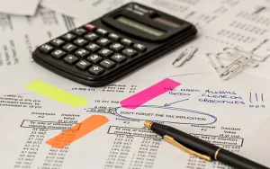 Tax Compliance Calculator and biro on top of paper